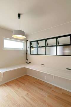 LDKの一角を格子で仕切りワークスペースに。室内窓が玄関から光と気配を運ぶ