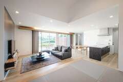 遮るものが何もない約22畳のLDK。目線が遠くへ抜けていき、より開放的に感じられる。幅の広いフローリングはPanasonic・アーキスペックフロア。小上がりの畳コーナーは来客をもてなしたり、ゴロンと横になったり