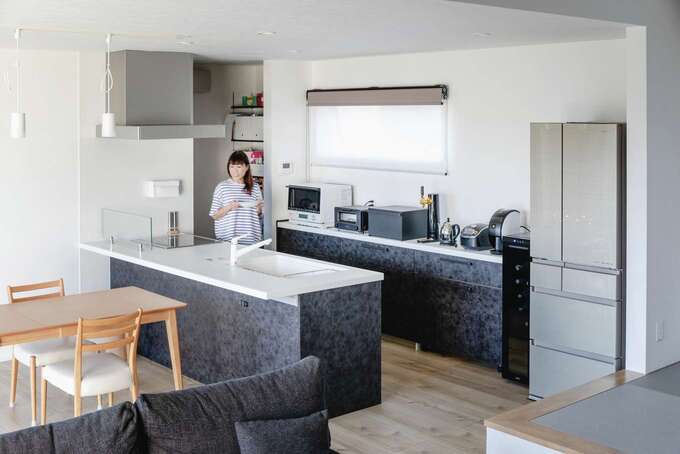 グレイッシュな床の色と質感に合わせてセレクトしたオープンキッチン。料理しながらテレビや庭の景色が見える
