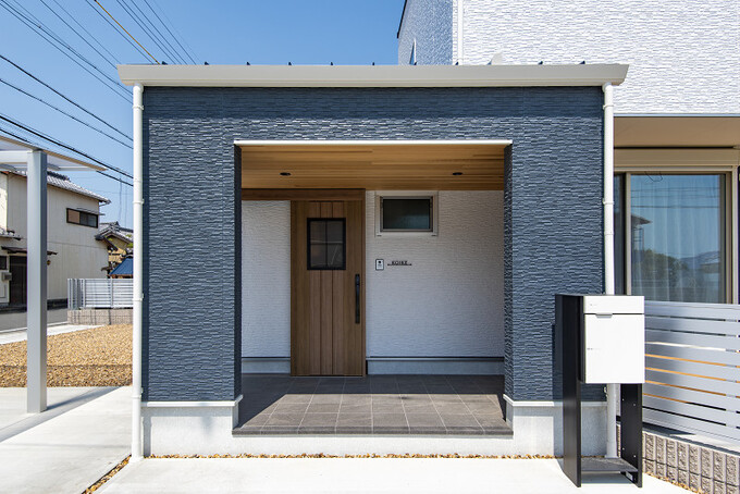 木目と石材を組み合わせたスタイリッシュな玄関。陽射しが差し込む開放的な空間で、訪れる人を迎え入れる
