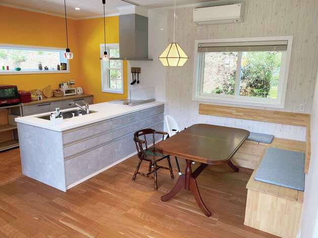 ダイニングの椅子は造作。キッチンの壁を黄色にすることで明るい印象に