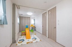 おもちゃとプレイエリアが確保された楽しい子ども部屋。明るい色合いの滑り台とカラフルなラグが遊び心を演出【イデキョウホーム】