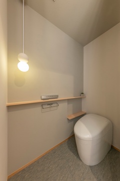 モダンなデザインのトイレ空間。シンプルな装飾と柔らかい照明が落ち着きを演出。コンパクトながら機能的な配置で快適。
