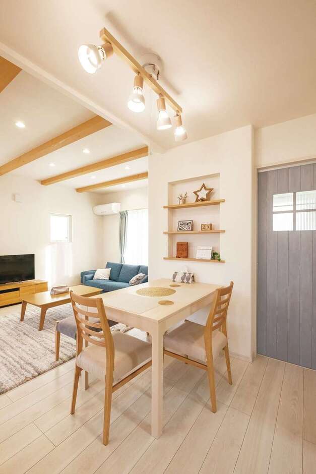 キッチンを奥にまとめたことで、リビングとキッチンの間にバランスよくダイニングスペースを配置できた。ペールブルーのドアで北欧風のイメージに