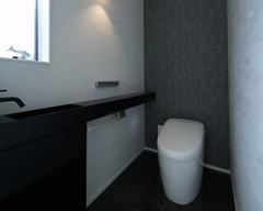 シックなカラーリングのトイレは、落ち着いた雰囲気を演出。壁に造り付けられたカウンターが実用性を高めている。