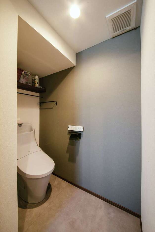 玄関側の階段下にはトイレを配置。グレーのアクセントウォールで落ち着いた空間に