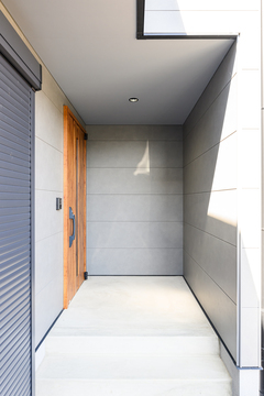 モダンなデザインの玄関スペース。シンプルでありながらも洗練された雰囲気を醸し出し、防犯性も考慮されている印象。