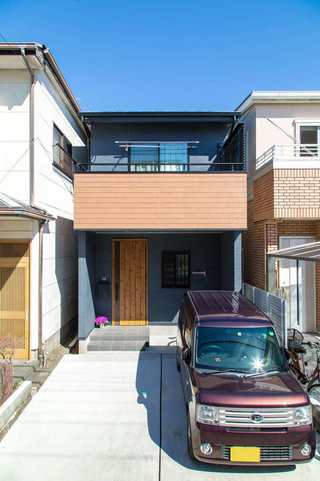 建物の前面に2台分の駐車スペースを確保。外観はグレーと木質のサイディングでヴィンテージ調に。2階リビングに面した大きなバルコニーも希望通り