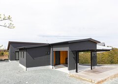 スタイリッシュなフォルムが美しいグレージュの平屋。奥行きは20mを超える。広い敷地を活かして、ガレージとカーポートを併設した。車がたくさん停められるため、友達も集まりやすい