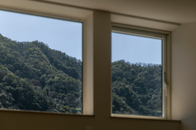 大きな窓から自然豊かな山の景色が広がる居室。窓辺から四季折々の風景を楽しむことができる贅沢な空間。