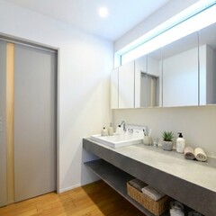 シンプルで機能的な洗面スペース。広いカウンターと大きな鏡が快適な使用感を提供し、収納も充実している。【木の花ホーム】