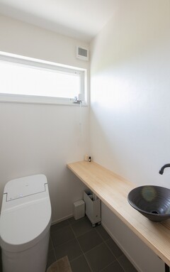 トイレにはゆとりのあるカウンターを設け、陶器のおしゃれな洗面ボウルを採用しています。【新和建設】