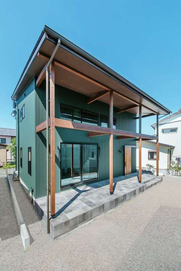 大屋根が作る深い軒が目を引く外観。イタリア産タイルをあしらったデッキで、プールを出して水遊びをしたり、BBQをしたり。軒下の柱にはハンモックやブランコを設置する予定