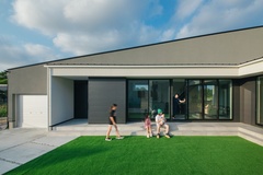 モダンなデザインの一戸建て住宅の外観。広々とした庭と大きな窓が特徴的で、自然の光をたっぷりと取り込む設計になっている。片流れの大屋根が印象的。【S.CONNECT（エスコネクト）】