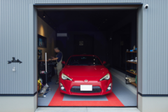 趣味の車を思う存分楽しめるインナーガレージ。アクセントで壁の一面に合板材を使用し、ヴィンテージな雰囲気を演出。快適に作業ができるようエアコンも完備している。【トヨタウッドユーホーム　群馬】