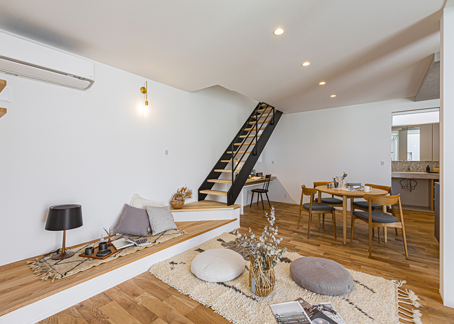 階段の位置、ソファーを置かない生活、中庭との繋がり方を意識して、階段の一段目をベンチにした。子どもが腰かけながら本を読んだり、ゲームをしたりする姿をキッチンからも見守れる