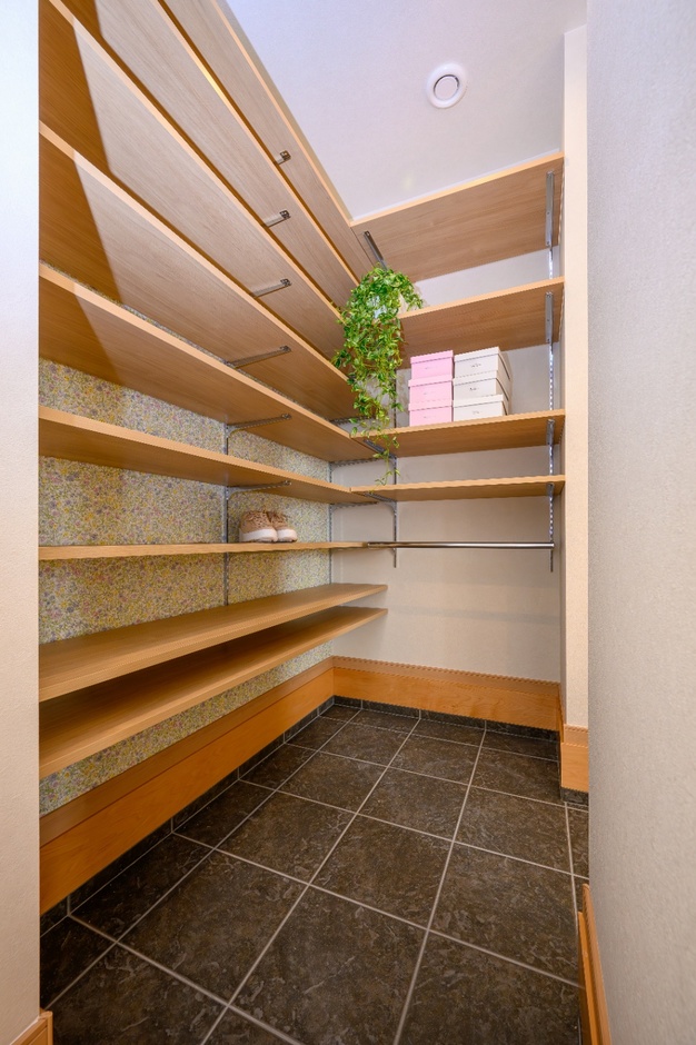 入って右手には大容量シューズクローク。小花柄のクロスが明るく可愛らしい空間にしてくれます。