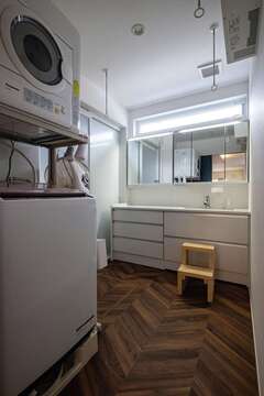 ヘリンボーン柄の床がおしゃれな洗面脱衣所。乾燥機は一年中活躍するがZEHのおかげで予想よりも光熱費がかからない