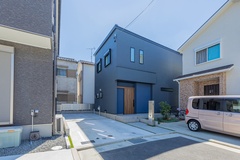 シンプルでモダンなデザインの外観。ダークカラーの外壁が特徴で、周囲の住宅と調和しつつも際立った個性を放つ。