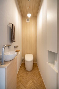 コンパクトで機能的なトイレ空間。木目調の壁とヘリンボーンの床が温かみを醸し出すデザイン。【クレバリーホーム愛知・三重・岐阜（住生活研究所）】