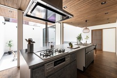 開放感あふれるアイランドキッチン。木の温もりを感じる床と天井が調和し、料理が楽しくなる空間である。【サンジョーホーム】