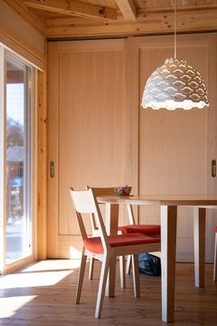 落ち着いた色調のダイニングスペースは、大きな窓から自然光が差し込み、明るく開放感がある。シンプルなデザインの照明が温もりを添える。