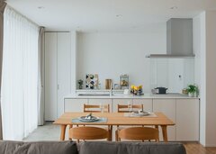 無垢の木の色に似合う、真っ白なキッチンは奥さまのセンスでセレクト。表側には扉付きの収納も用意されている【DAITOKU（大得工務店）】