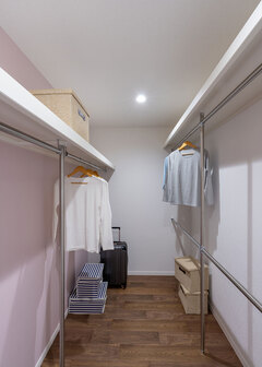 ウォークインクローゼットは、リビングと直結。左右のポールの高さや本数を変える工夫で、収納力をアップさせた