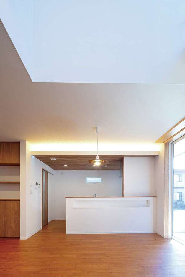 キッチンは、木目調の下がり天井を活かして間接照明を設置。夜は調光したほのかな灯りでくつろぎの空間を演出