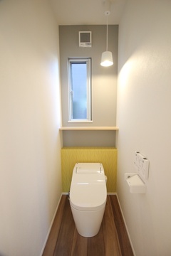 グレー×イエローのトイレ空間。自然光が入り込む小窓があり、明るさと通気性を確保している。【小野田産業～designers house project～】