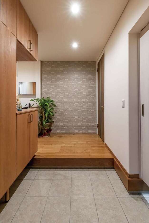 モダンで重厚感のある玄関ホール。正面の壁は外壁に使うタイル素材。収納も充実している