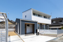 白と青のコントラストが美しい、モダンな二階建て住宅の外観。周囲と調和しつつ、モノトーンのフェンスが洗練された印象を与える。【トキワハウス デザイン アンド ビルド（常盤工業）】