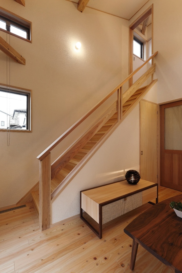 木材をふんだんに使用した階段。自然光が差し込み、温もりのある雰囲気。シンプルなデザインが空間を引き立てる。