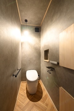 落ち着いた色調のトイレ空間。ヘリンボーンの床材と壁面収納がスタイリッシュ。【REIWA HOUSE（令和ハウス）】