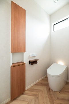 温かみのある木目調と白を基調とした落ち着いたトイレ空間。コンパクトながらも明るい採光があり、清潔感が漂うデザイン。【オールハウジング】