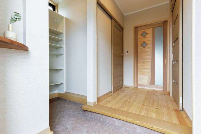 シューズクローク付きの玄関。リビングドアは深澤社長がデザインしたオリジナル建具で、OBからも大好評