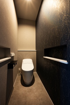 グレーやブラックを中心とした住まい全体のトーンに合わせ、トイレ空間も落ち着きのあるダークカラーで統一。【スズイチ】