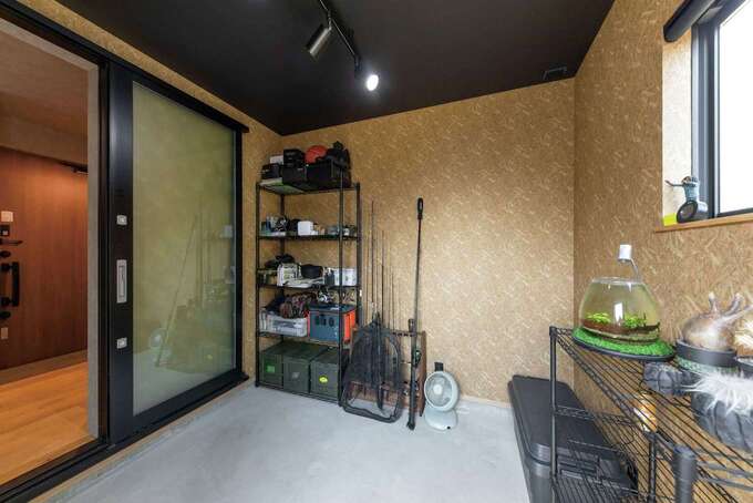 釣具やアウトドアアイテムが並ぶご主人の趣味部屋は、外からそのまま出入りできる土間仕様に。観葉植物やアウトドアチェアを置いて、くつろぎ時間を過ごすスペースにカスタマイズしていくそう