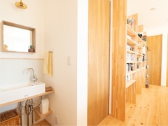 シンプルかつ機能的な洗面スペースに、インテリアデザインを崩すことなく趣味を世界を取り入れた可動棚も。