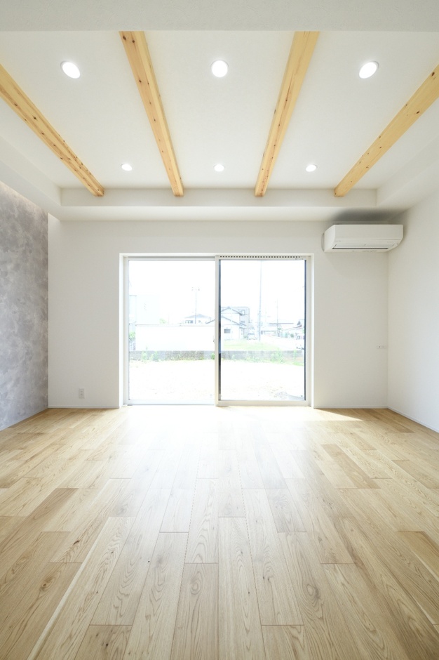 開放的なリビング空間。大きな窓から自然光がたっぷり差し込み、明るさと広がりを感じさせる。