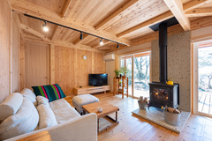 木の温もりが感じられるリビングスペースでは、薪ストーブが風情を引き立て、落ち着いた空間でリラックスできるようになっている。