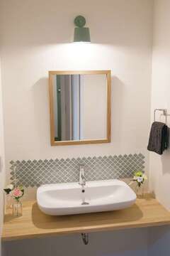 玄関の突きあたりにある洗面スペース。帰宅してから手を洗ってＬＤＫへ…という効率的な動線を確保。奥さまが壁にタイルのシールを貼ってオシャレに演出