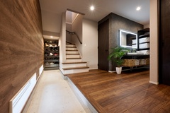 暖かみのある木材が使われた玄関ホールで、階段が奥に続くデザイン。棚には靴が収納され、整然とした空間を維持している。