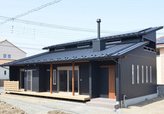 大きく出した軒と薪ストーブの煙突が印象的。夏の日差しは大きく出た軒で遮りつつ、冬の日差しを家の中に招き入れる