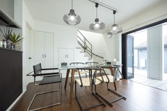 明るい光が差し込むダイニングエリア。モダンな照明とインテリアがアクセントとなり、食事の場を演出する。