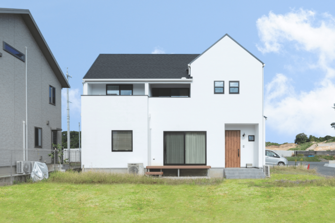 白い塗り壁に三角屋根が青空に映える、可愛らしい外観。