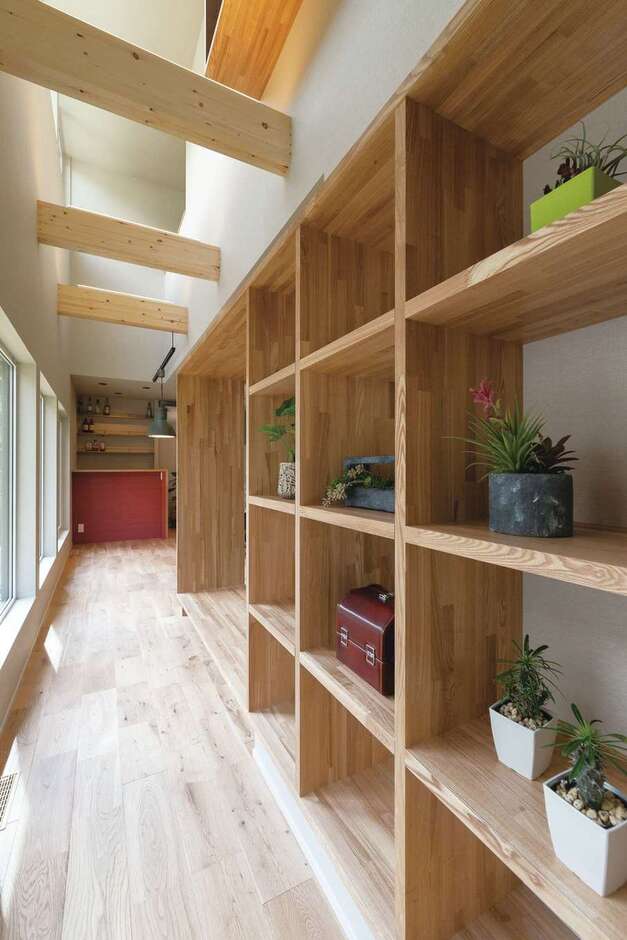 廊下の壁に設けた本棚は奥さまの希望で。さながら日当たりのいいライブラリー。蔵書が並ぶのが楽しみ