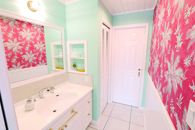 パームツリー柄の壁紙をポイントにしたバスルーム。水回りは、あえて遊び心あふれる壁紙を選んだそう