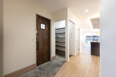 玄関横にはシューズクロークを設け、靴やアウトドア用品などをしっかり収納。
生活感を抑え、いつでもすっきりとした玄関を保てます。
奥へと続く動線の先にはリビングが広がり、やわらかな光が玄関ホールまで届く設計に。【丸宗建設】