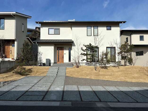 「外壁は塗り壁に」という特殊な条件のある敷地だったが、実績ある同社が問題なく対応。飽きのこない表情に仕上がった。道路から室外機が見えないよう配慮も